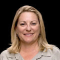 Woman with blonde hair wearing a beige shirt in an indoor setting